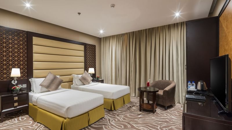 Junior Suite with twin beds and a separate seating area at Warwick Hotels and Resorts, with modern decor