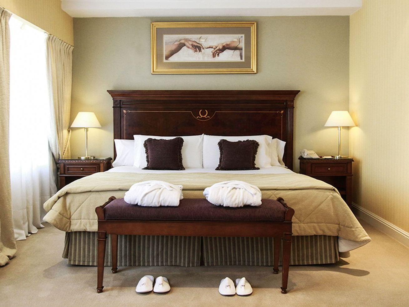 Una cama y un banco al pie de la cama en el Hotel Emperador Buenos Aires
