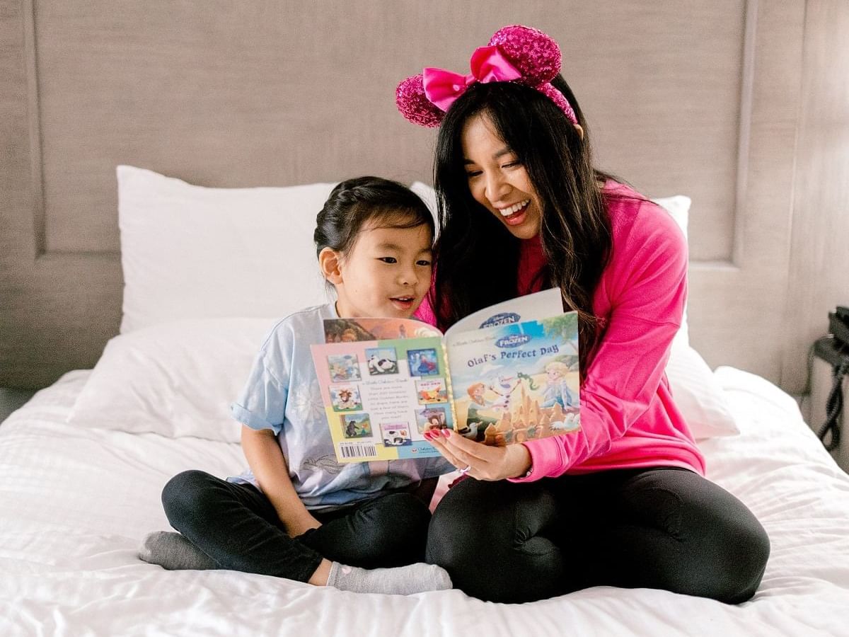 Mother and child reading a storybook together on a bed promoting the Welcome Home Special.