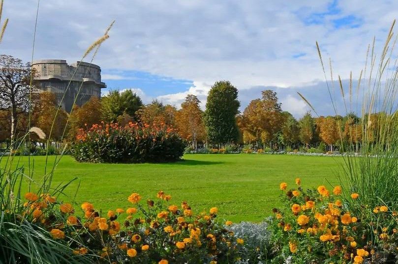 Vienna Augarten park with blooming flower beds, green lawns and autumn scenery