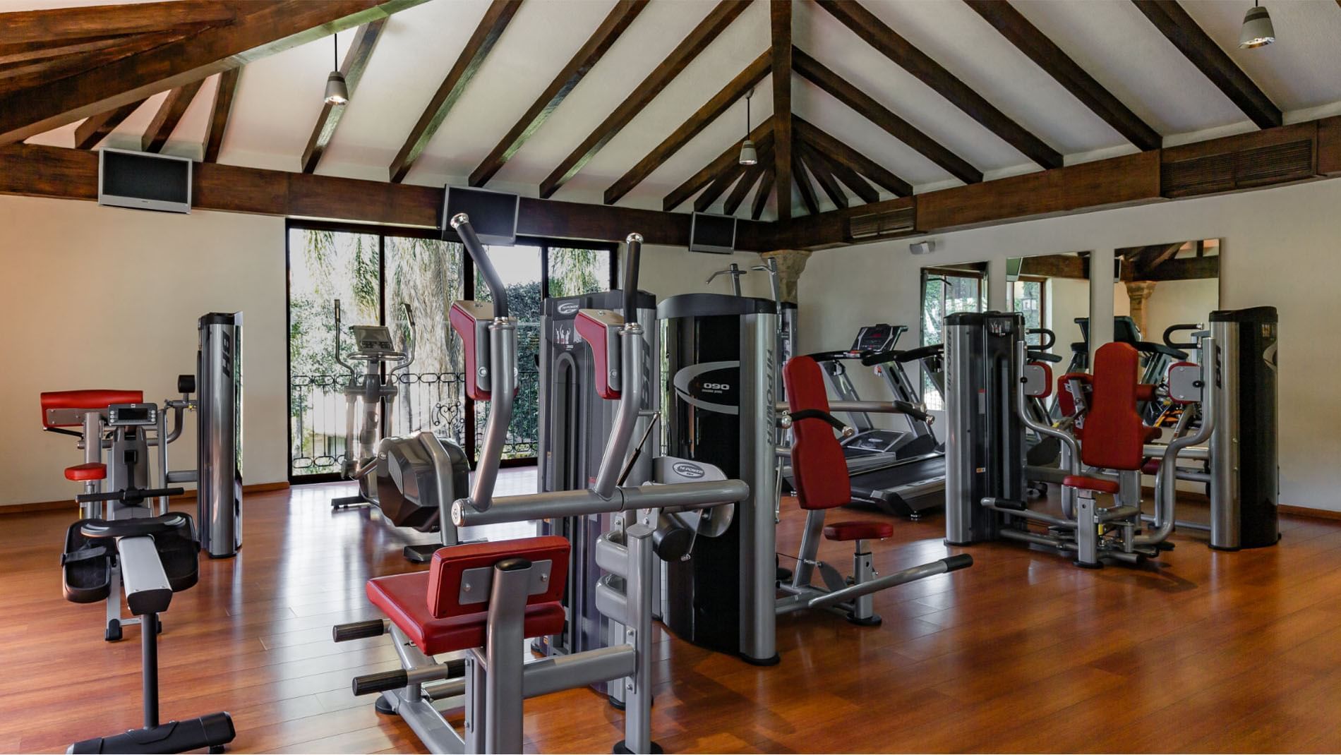 fitness center with modern weight machines and wooden floors at Quinta Real Guadalajara