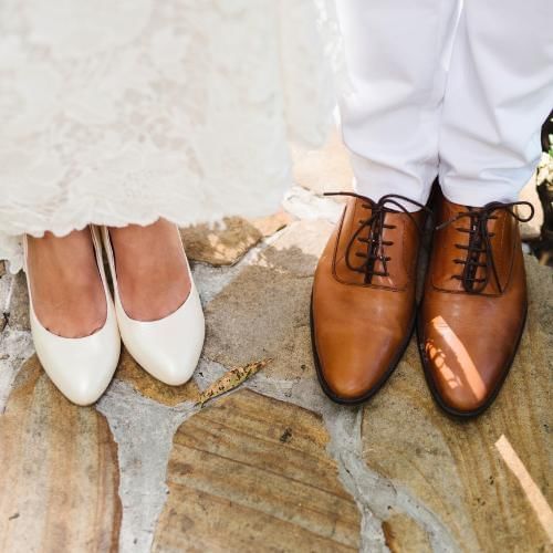 Bride and groom about to step on each others shoes which is a traditional Turkish wedding tradition