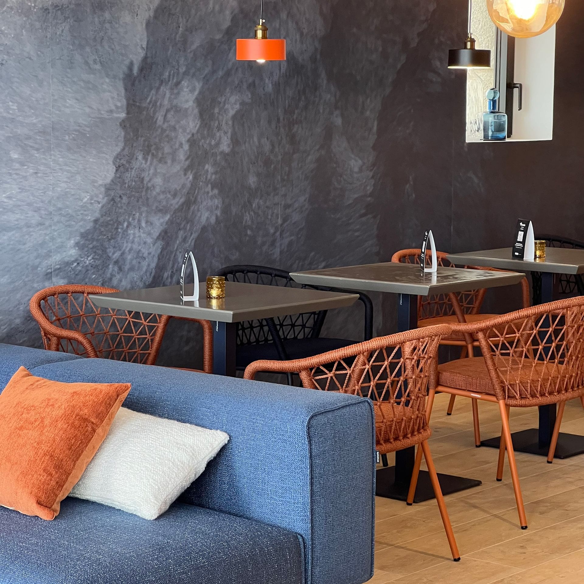 Arrangement de table à manger à côté d'un canapé bleu dans un restaurant à Oceania Saint-Malo