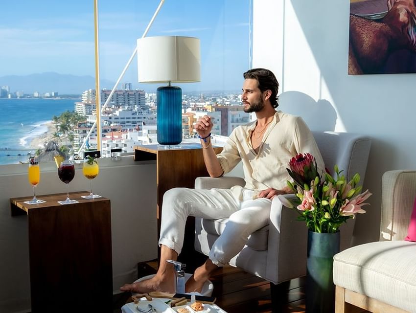 Man enjoying a cocktail with a cityscape ocean view at Almar Beach Resort
