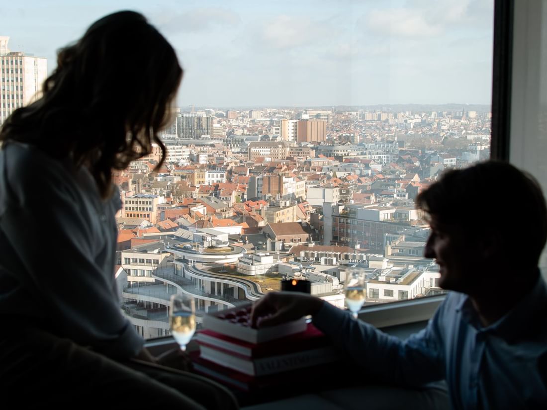 Couple looking outside through a large window at The Hotel Brussels
