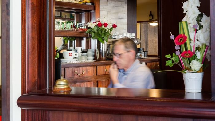 A receptionist at the reception desk in Hotel du Chateau