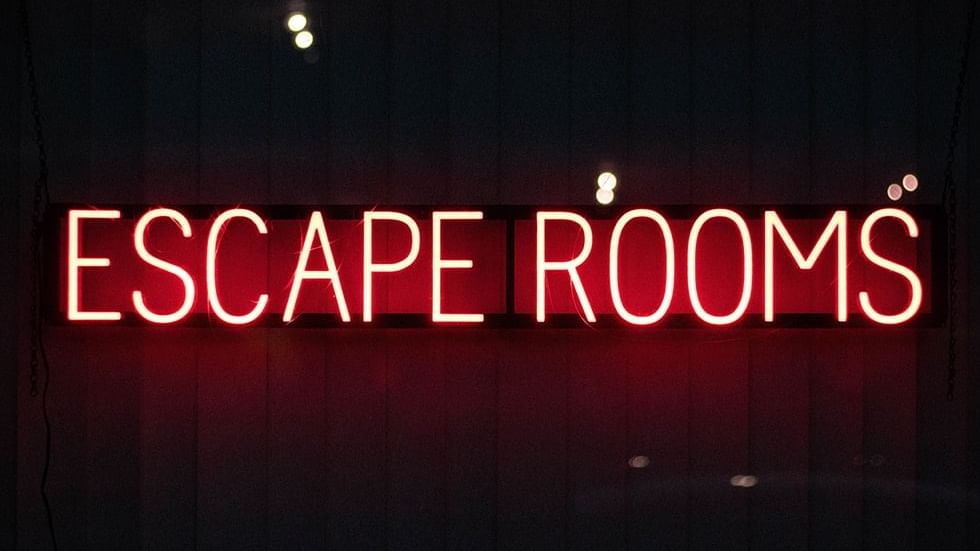 Red neon sign reading 'ESCAPE ROOMS' in a dark background at Falkensteiner Hotel Belgrade