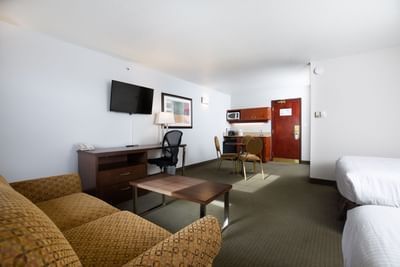 TV, workspace & couches facing the beds in Standard Family Suite at Service Plus Inns & Suites