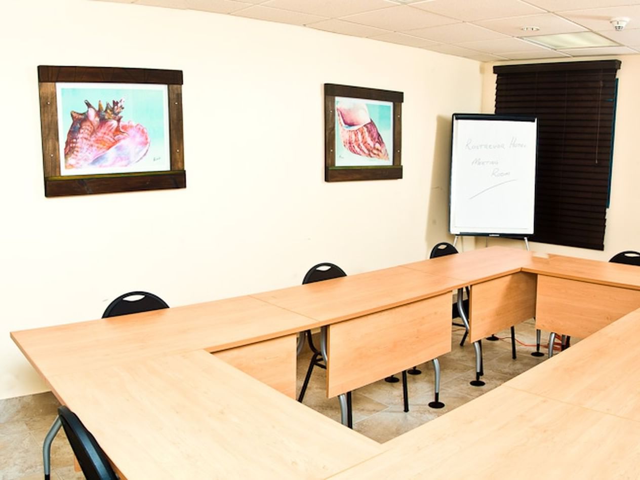 Modern conference room with a wooden table, chairs, artwork, and a flip chart at Rostrevor Hotel