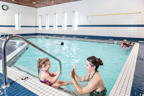 Mom and daughter in indoor swimming pool