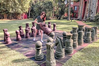 Uma garota jogando xadrez gigante ao ar livre no Iguazu Grand Resort