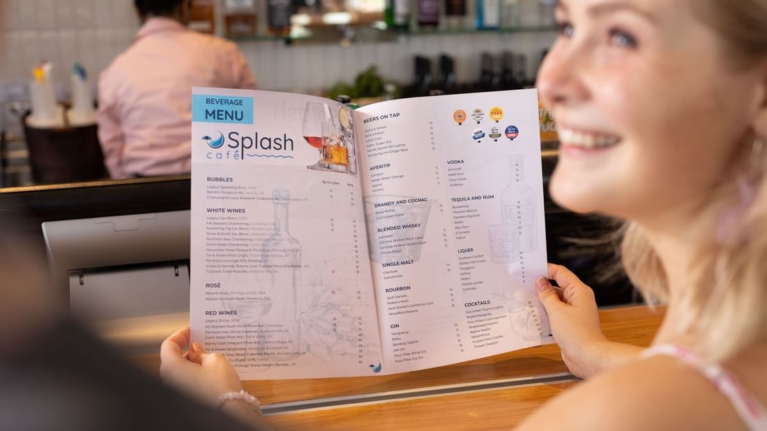 Woman with a menu card in Splash Cafe at Novotel Darwin Airport