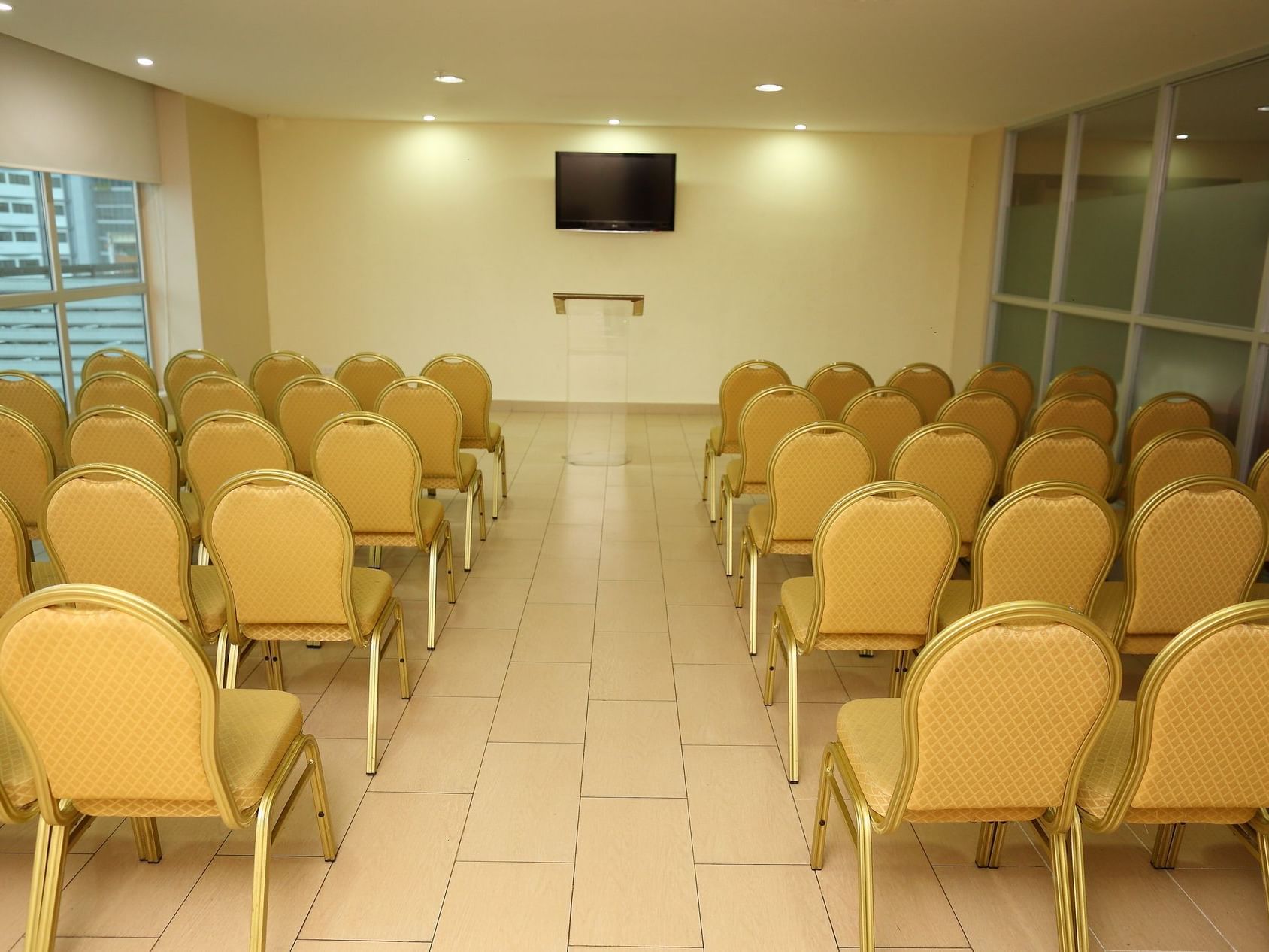 rows of chairs facing a tv