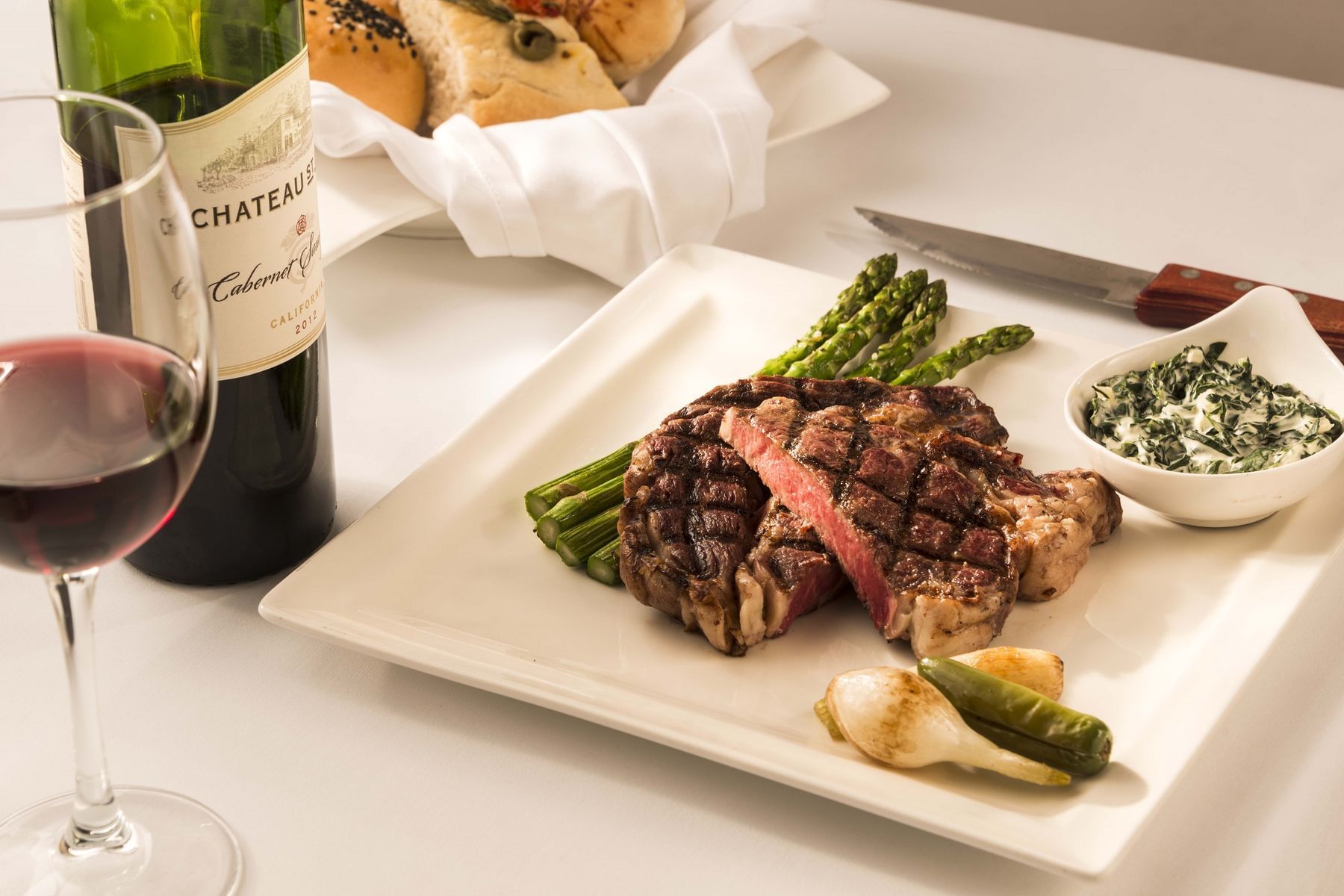 Closeup of a steak dish served with wine at Marquis Reforma