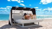 Lady lounging on a beach cabana by the sea near Diplomat Beach Resort