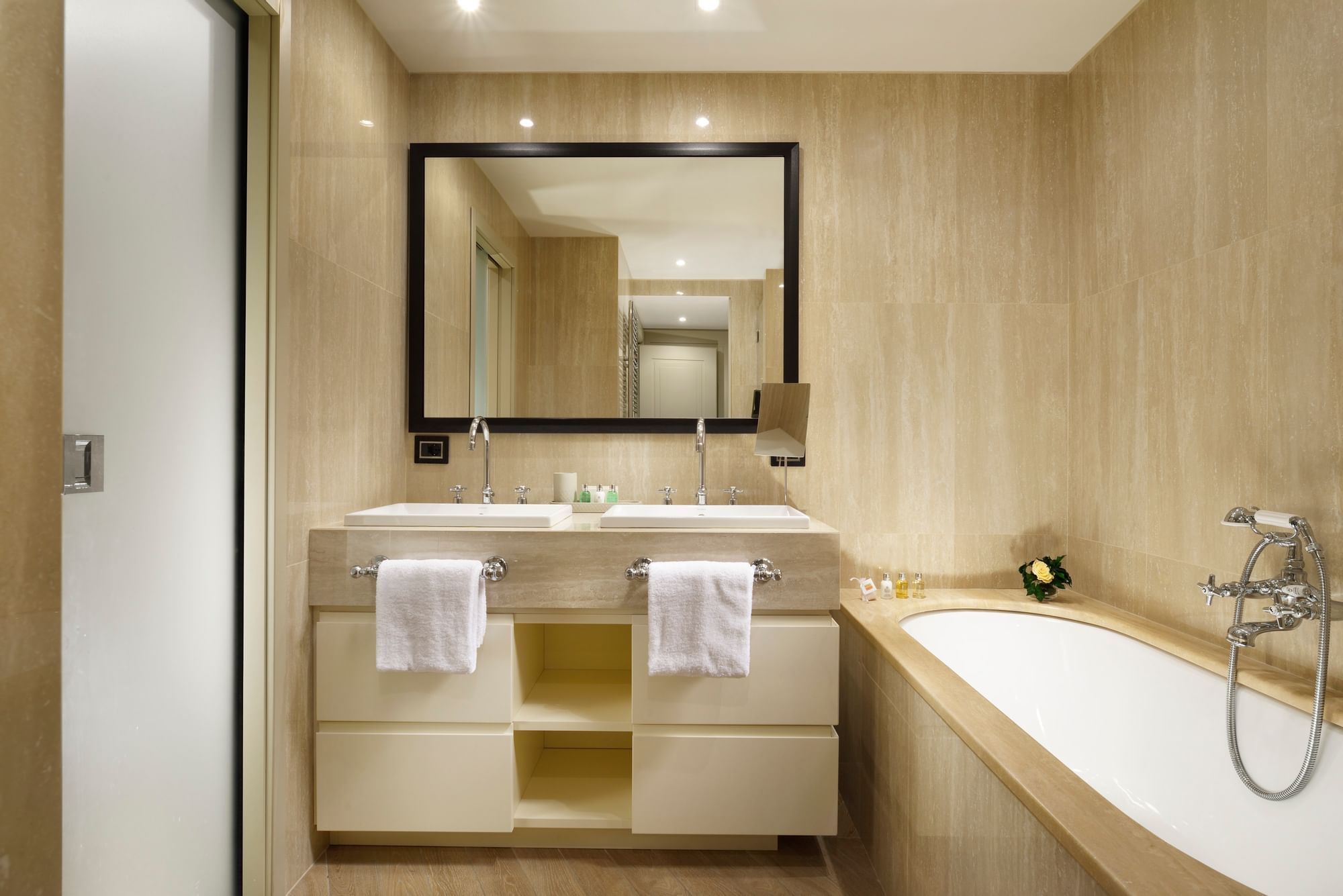 Bathroom vanity with a bathtub and a large mirror in Margutta Suite at Margutta 54