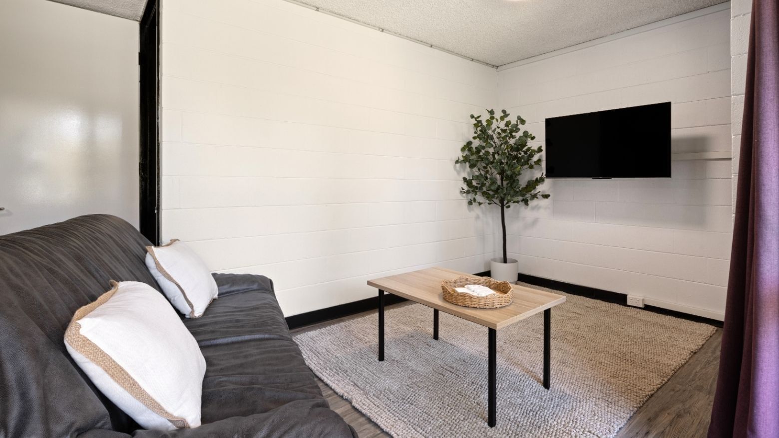 Living room with couch, pillows, and coffee table at UniLodge at Curtin University - Guild House.