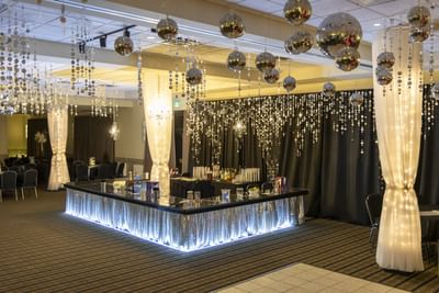 Dynamic bar counter by a dance floor under disco balls, with curtains in an event hall at Rodd Miramichi River
