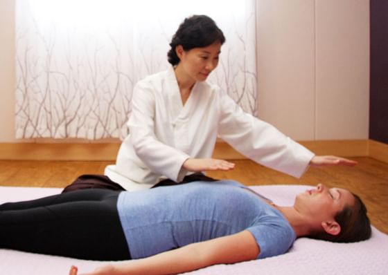 Woman doing energy healing on patient