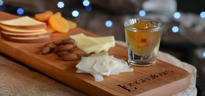 Charcuterie board with cheese, nuts, fruit slices, and beverage