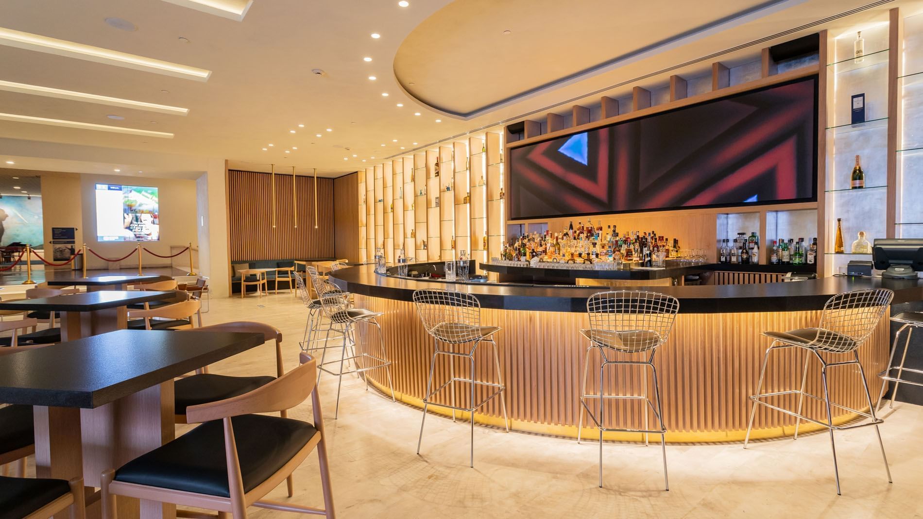 Modern circular Blue Bar with wood paneling, wire stools, and ambient lighting at Camino Real Polanco Mexico