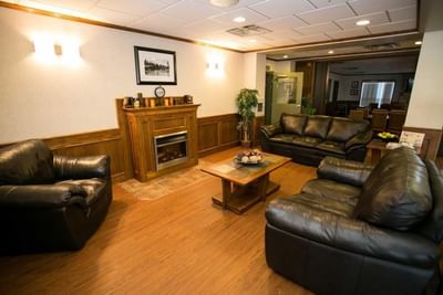 Fireplace by the lobby lounge area with wooden floors at Service Plus Inns & Suites Drayton Valley