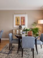 Gray chairs surrounding a round table by a desk in The Champs-Élysées Suite at Warwick Paris Champs Elysées