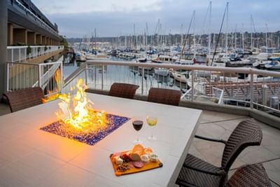 Wine & cheese platter on a fire table outside at Bay Club Hotel