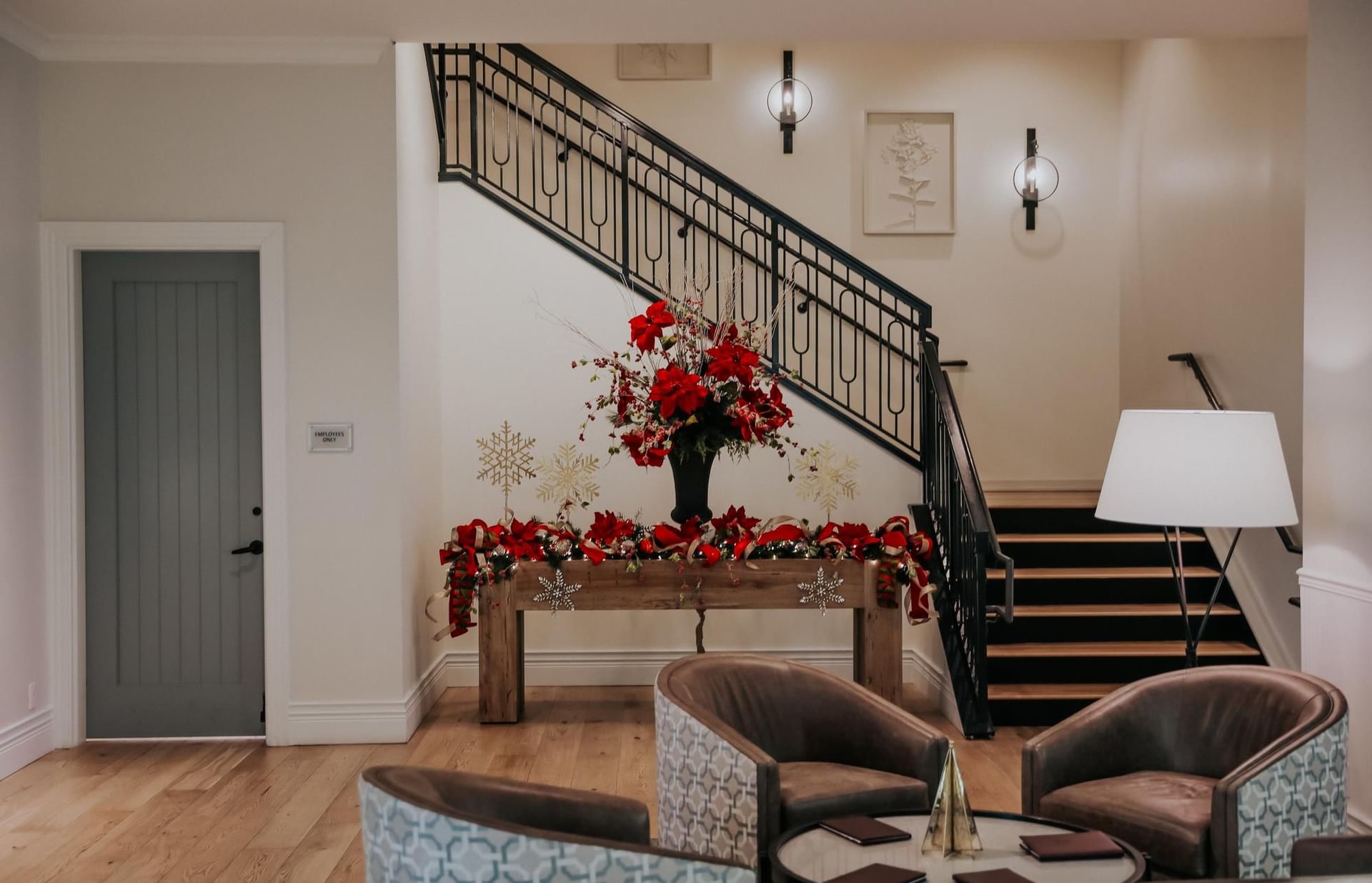 Stairs and sitting area with red flowers and gold and white Christmas decor.