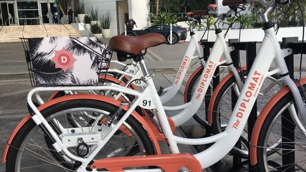 A row of neatly lined Diplomat bicycles parked together outdoors at The Diplomat Resort