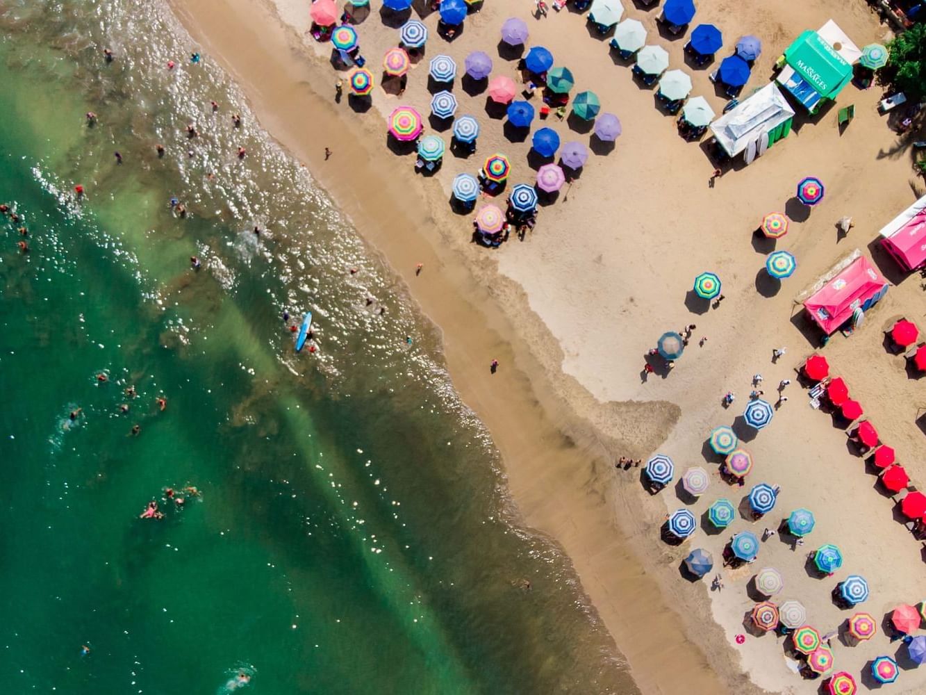 Aerial view of Sayulita Beach with colorful umbrellas near Plaza Pelicanos Grand Beach Resort