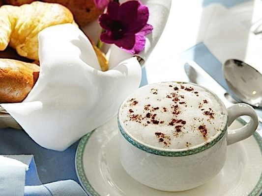 Cup of Cappuccino beside buns at Casa Colonial Beach and Spa