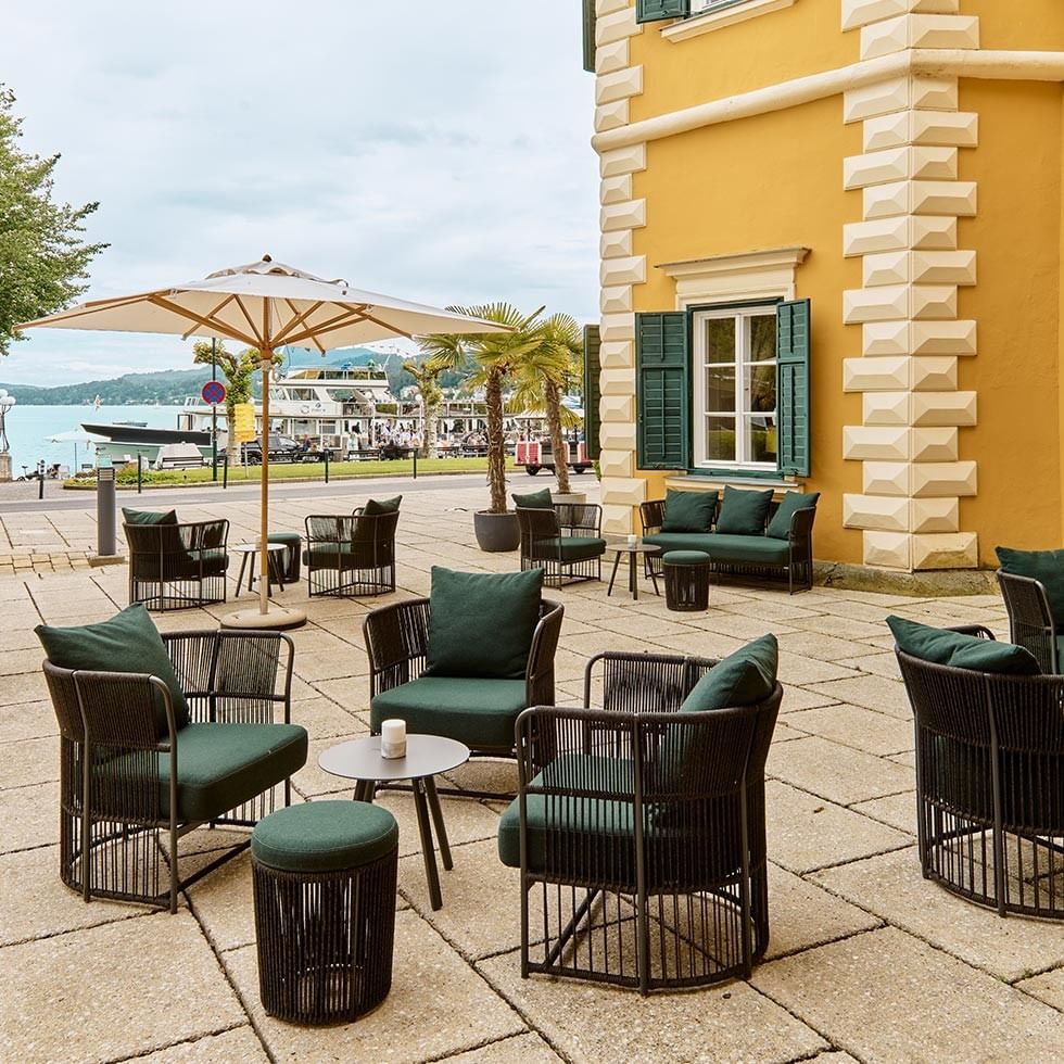 Elegante Schlossbar mit Live-Musik im Freien, umgeben von See und Palmen.