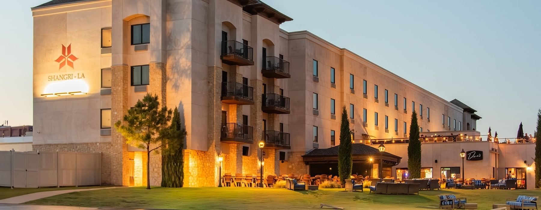 A vibrant, multi-colored parasail canopy soaring through a blue sky with white clouds at Shangri-La Resort and Golf Club