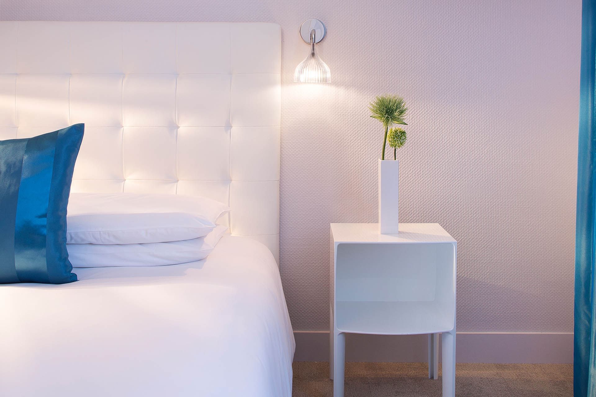 Gros plan du lit et de la table de nuit dans une chambre à Escale Oceania Lorient