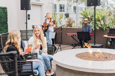 People enjoying cocktails & live music in Topside Terrace Kitchen & Bar at Hotel Republic San Diego