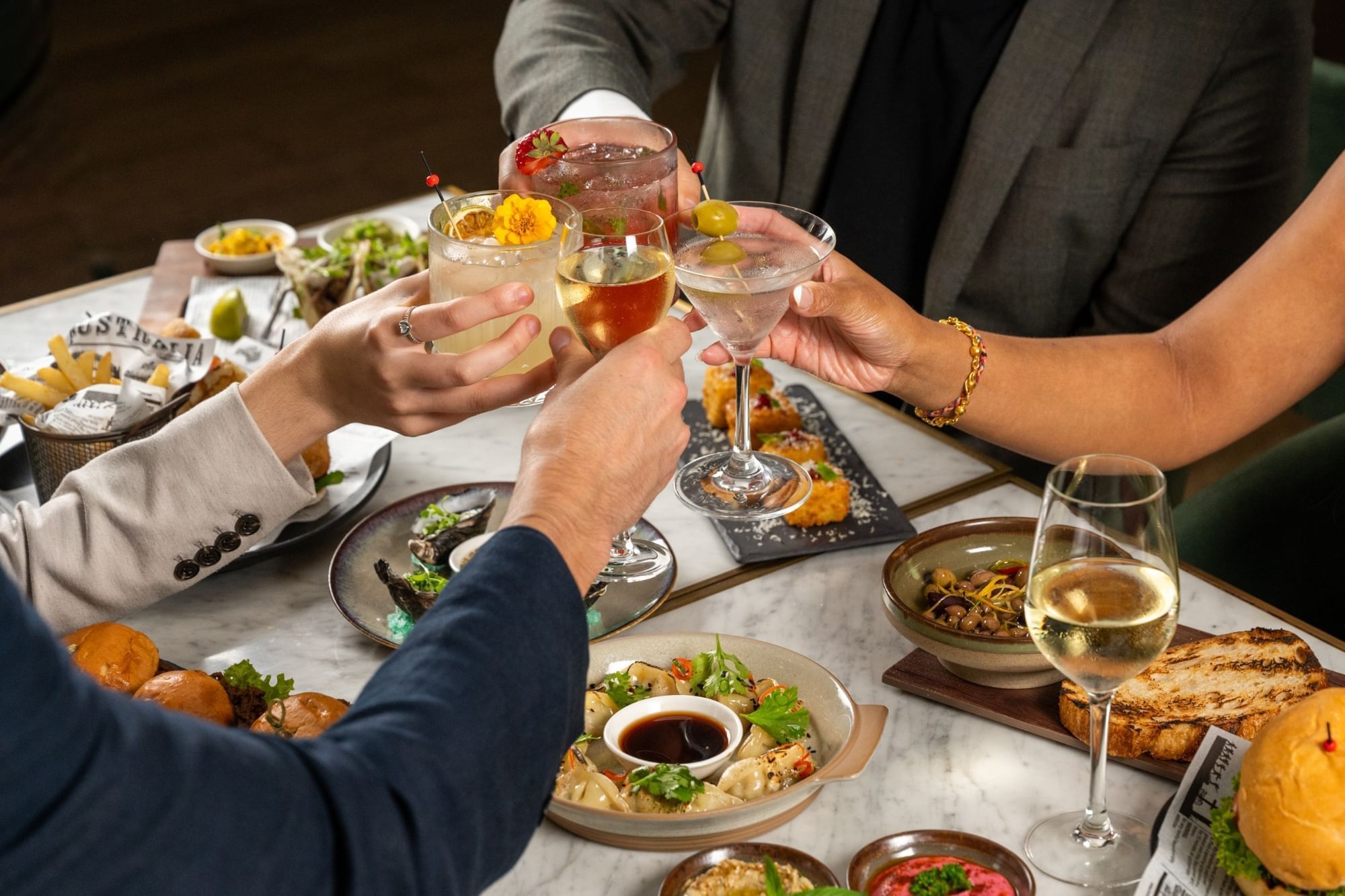 Close-up of a group of people toasting cocktails in BAR THIRTY6 at Pullman Sydney Hyde Park