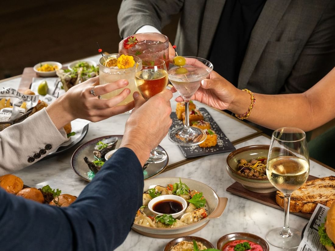 Close-up of a group of people toasting cocktails in BAR THIRTY6 at Pullman Sydney Hyde Park
