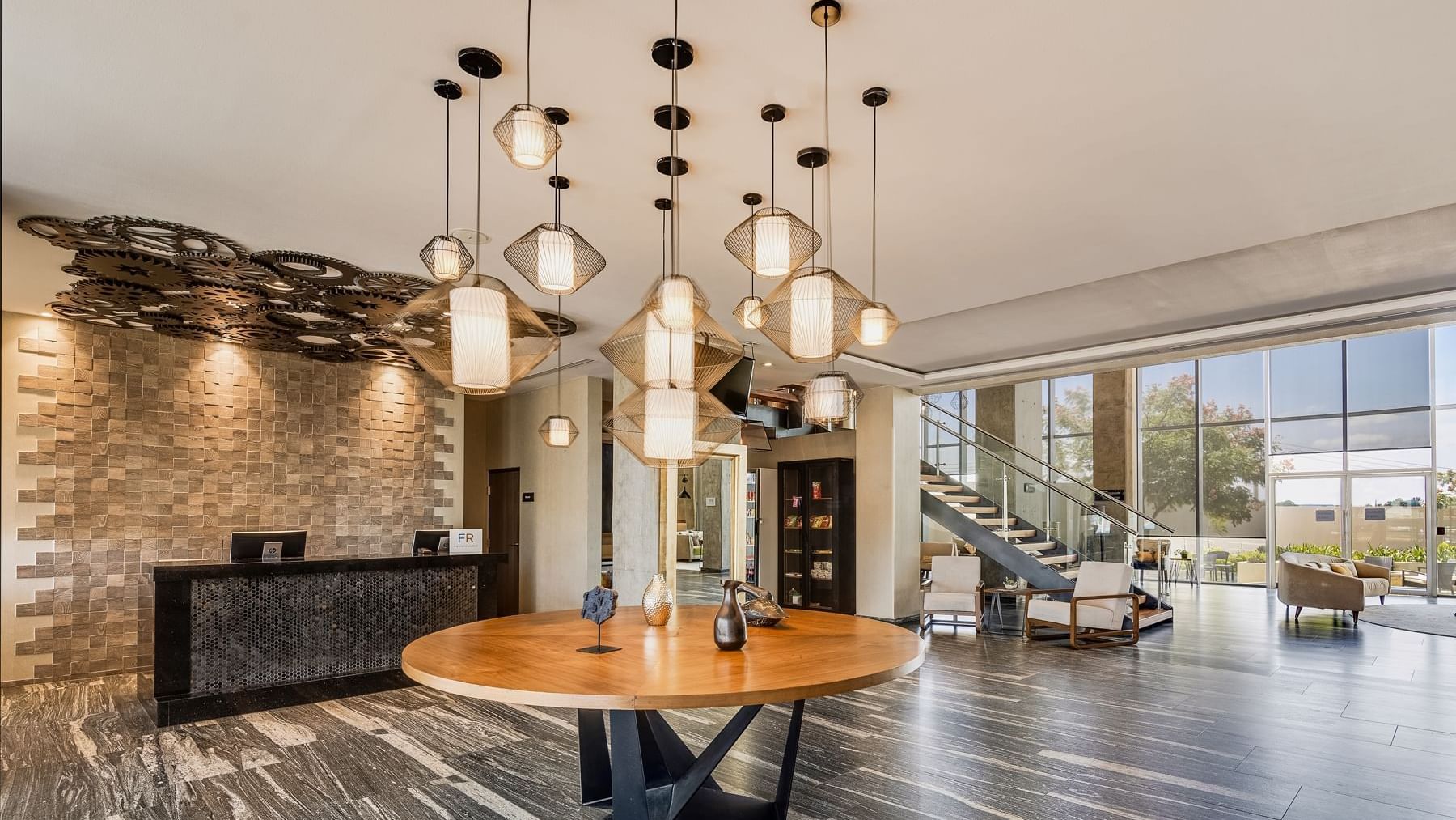Modern lobby with artistic lighting and reception desk at Fiesta Inn Suites Aeropuerto del Bajío