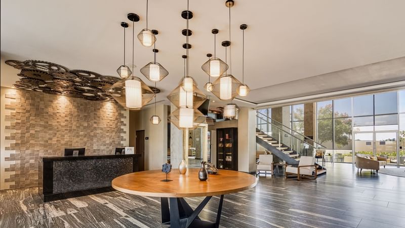 Modern lobby with artistic lighting and reception desk at Fiesta Inn Suites Aeropuerto del Bajío