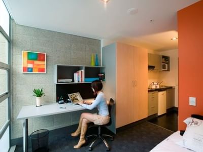 Student studying at desk in modern studio apartment