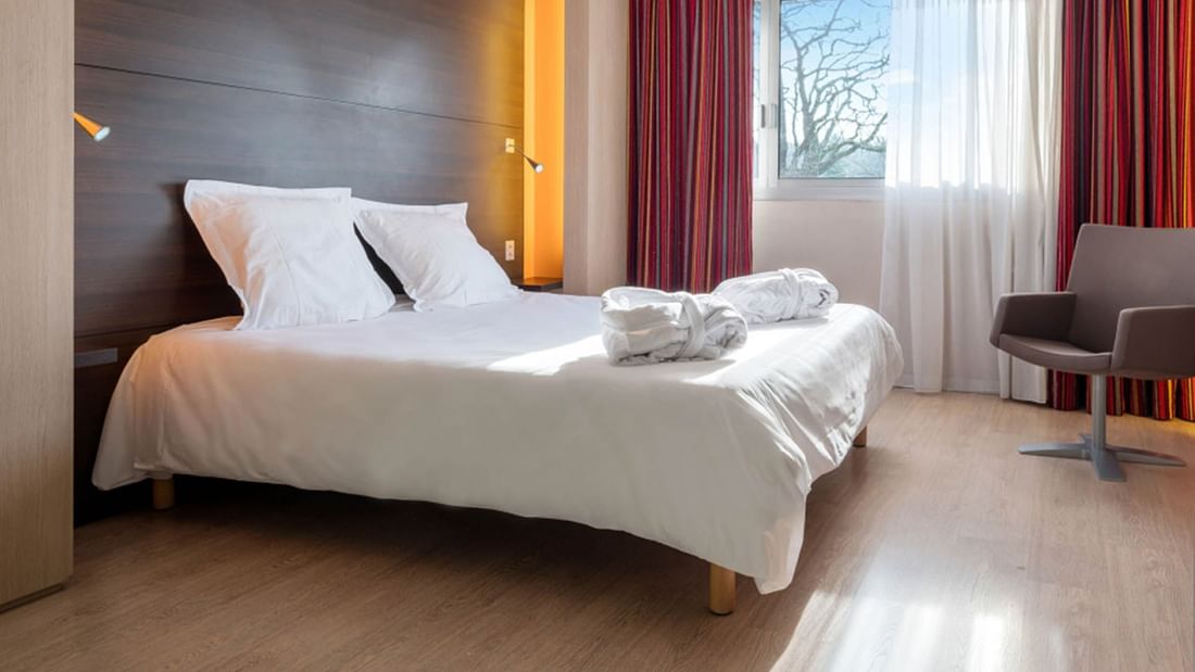 King-size bed, chair in Superior room at Oceania Quimper
