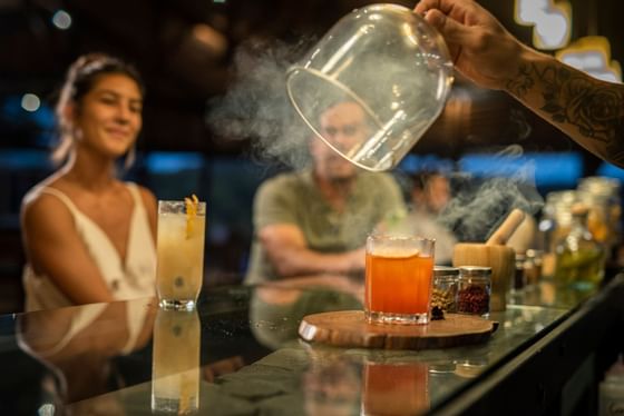 Bar tender presenting a cocktail in the bar counter at Hotel Rio Perdido