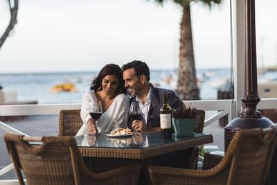 Couple enjoying wine by the seaside at Avalon Grille in Pavilion Hotel Catalina Island