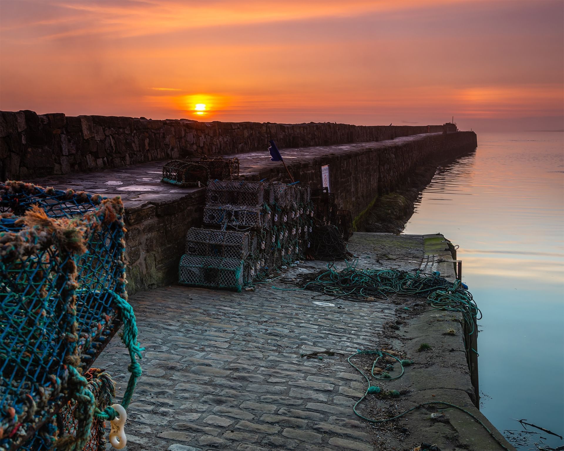 Sunset in St Andrews Pierpier with fishing equipment and a calm sea near Luxury Hotels Fife