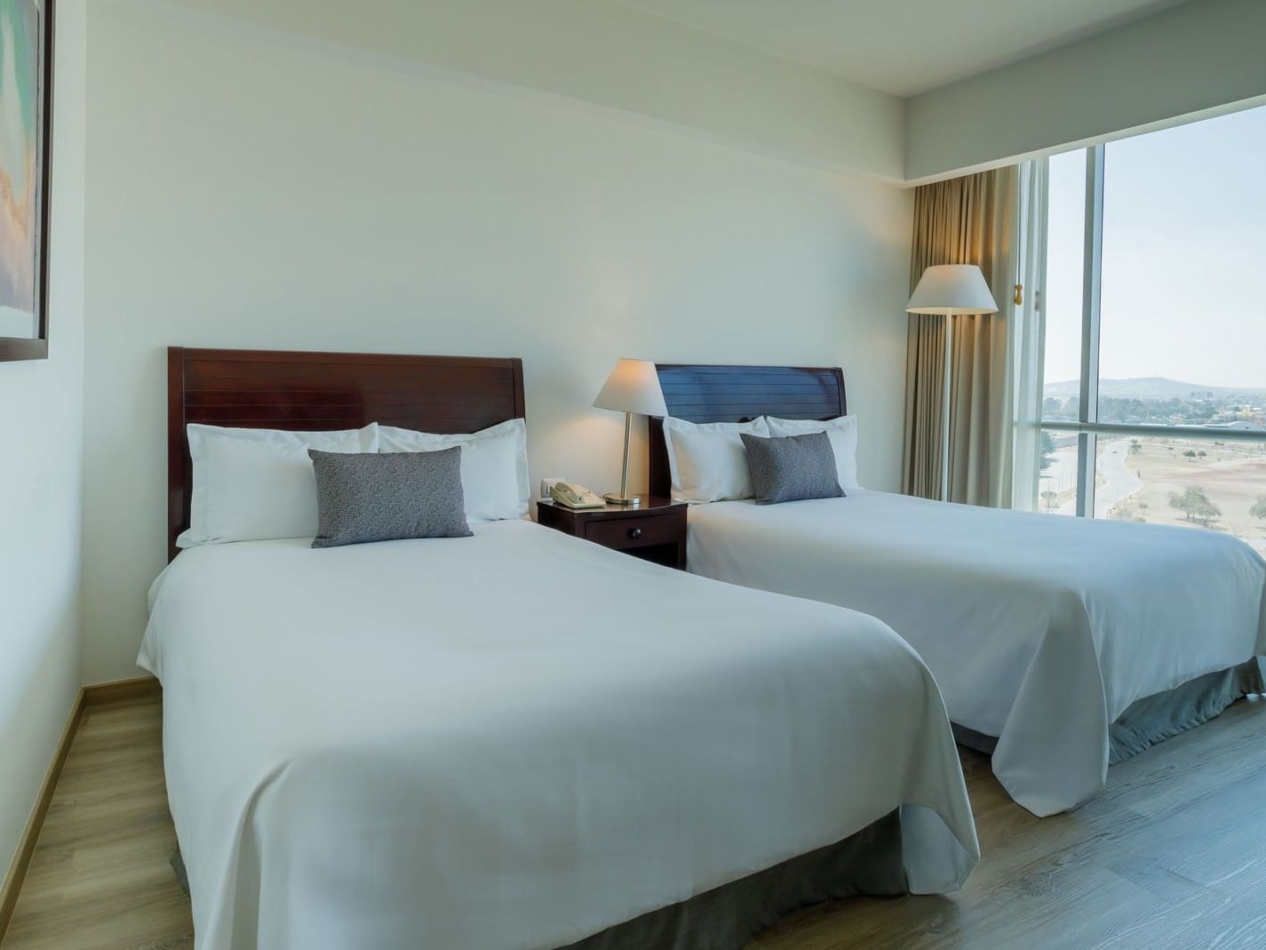 Well-lit 2 Double Camino Real Club featuring white linens, grey pillows, and a scenic valley view at Camino Real Pachuca