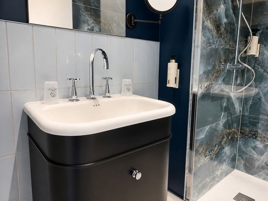 Salle de bains élégante avec douche et lavabo au Osmo Hôtel Chantepie.