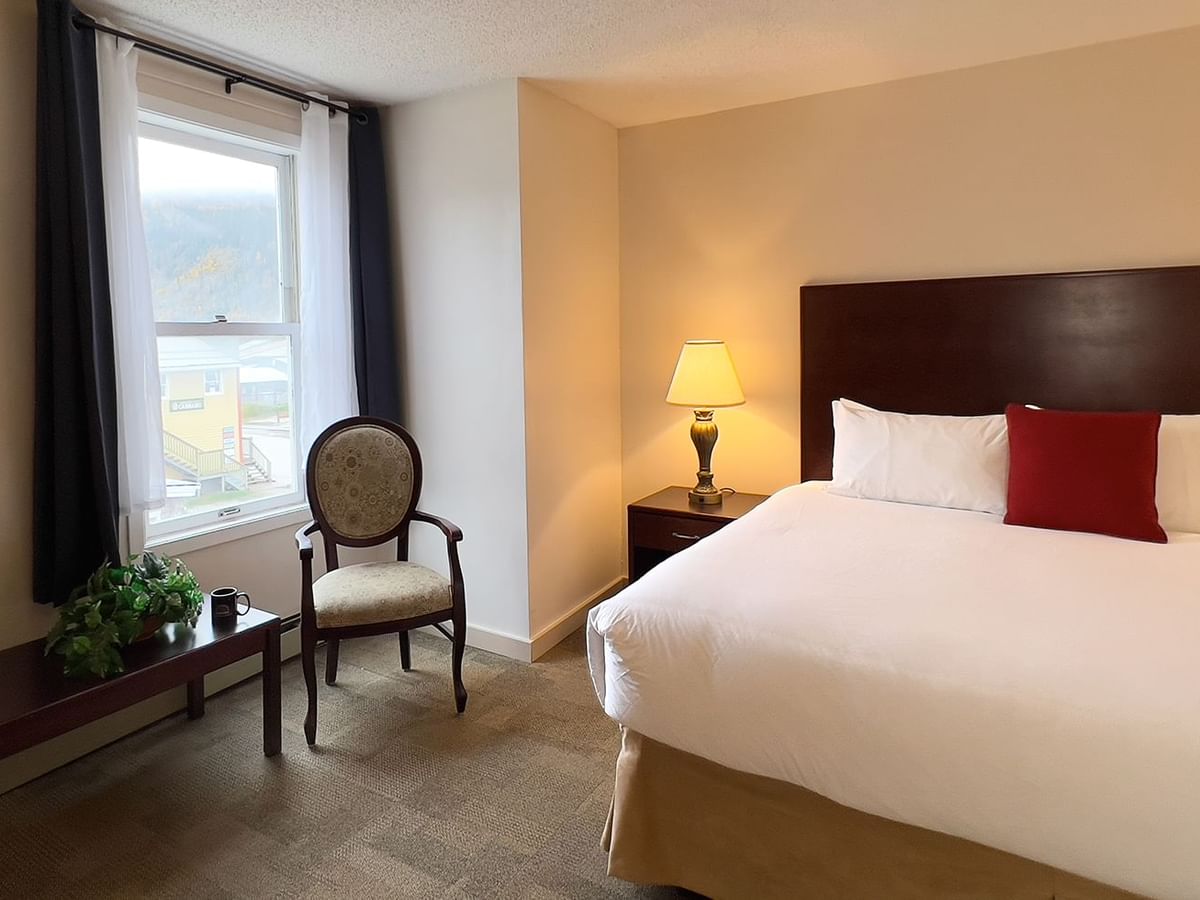 Bedroom suite with bed, window, chair, and table