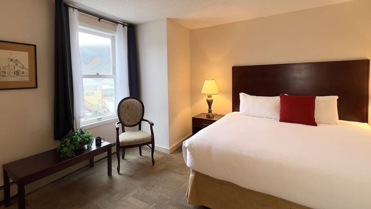 Bedroom suite with bed, window, chair, and table