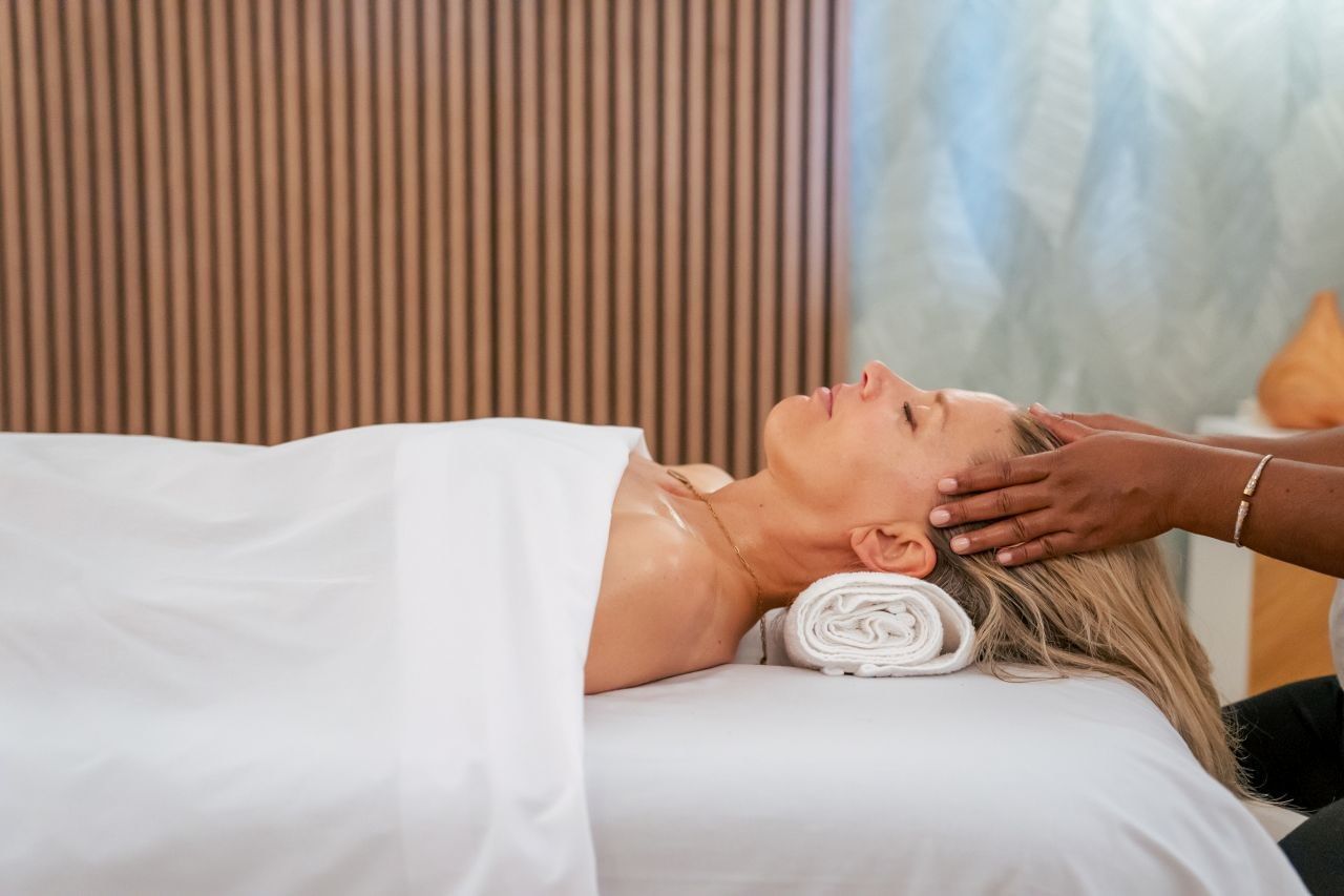 Woman receiving a relaxing head and scalp massage on a treatment bed in The Rock Spa at Golden Rock Resort